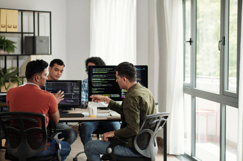 Developers Discussing Programming Code - Pionieri del Tech